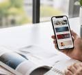 Người dùng xem feed nội dung trên điện thoại trong không gian làm việc sáng